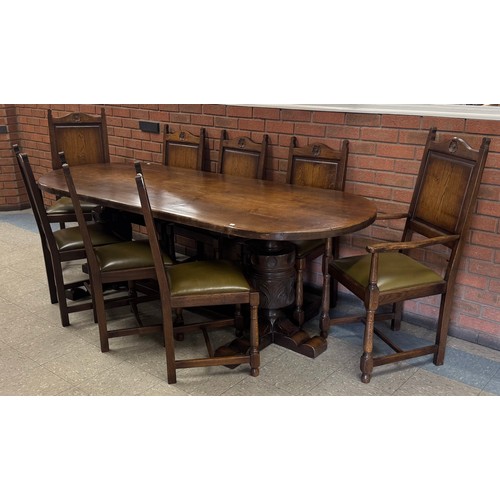 141B - A 17th Century style carved oak oval refectory table and eight chairs