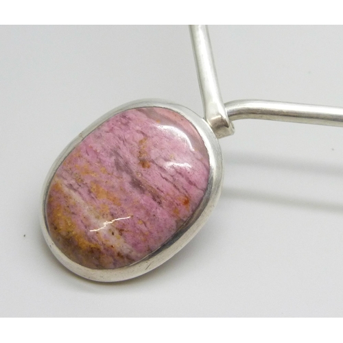 7071 - A silver torque necklace set with a cabochon pink gemstone, 32g, 3.1cm pendant