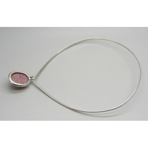 7071 - A silver torque necklace set with a cabochon pink gemstone, 32g, 3.1cm pendant