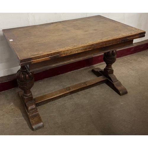 175A - An early 20th Century carved oak draw-leaf table