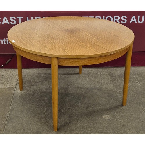 15 - A teak circular extending dining table