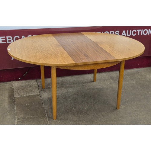 15 - A teak circular extending dining table
