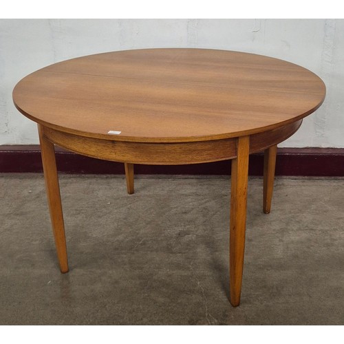 17 - A teak circular extending dining table