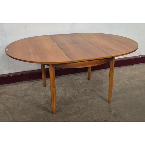 17 - A teak circular extending dining table
