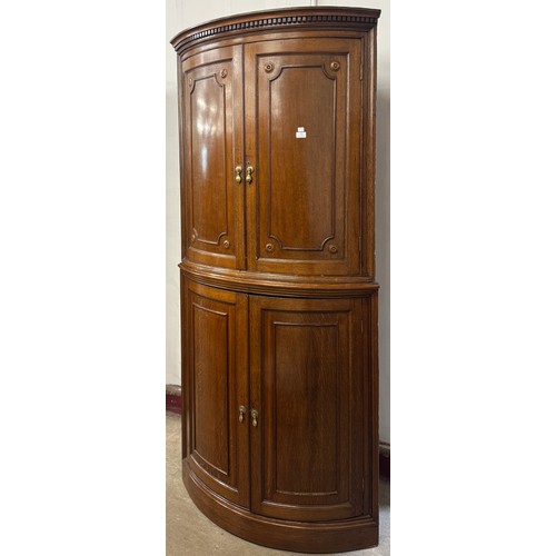 111 - A Victorian oak bow front freestanding corner cupboard
