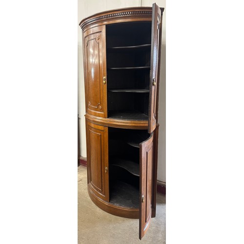 111 - A Victorian oak bow front freestanding corner cupboard