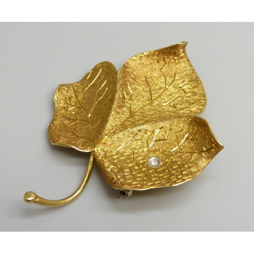 7026 - An 18ct gold brooch in the form of a leaf, set with a diamond, 8.2g, 5.2cm
