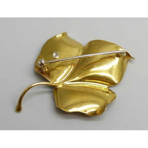 7026 - An 18ct gold brooch in the form of a leaf, set with a diamond, 8.2g, 5.2cm