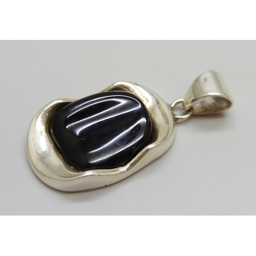7046 - A hallmarked Modernist style silver pendant set with a red stone, possibly cherry amber Bakelite or ... 