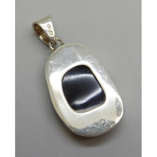 7046 - A hallmarked Modernist style silver pendant set with a red stone, possibly cherry amber Bakelite or ... 