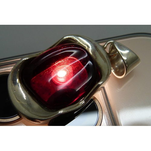 7046 - A hallmarked Modernist style silver pendant set with a red stone, possibly cherry amber Bakelite or ... 
