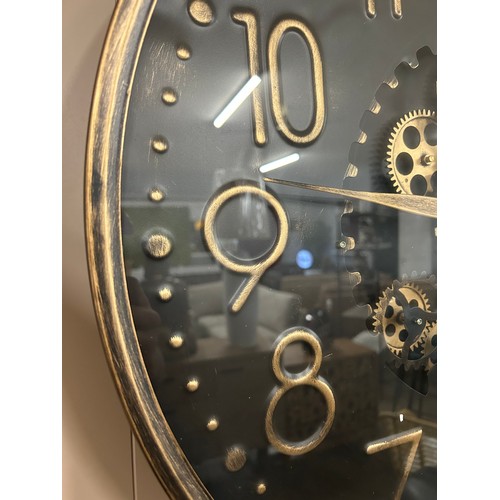 3042 - A black and gold effect circular, moving gear wall clock