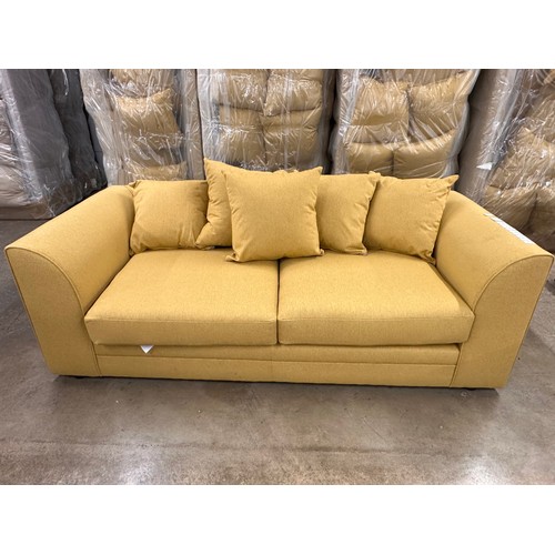 3121 - A mustard fabric upholstered three seater sofa, bagged