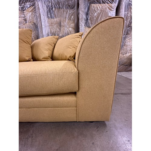3131 - A mustard fabric upholstered three seater sofa