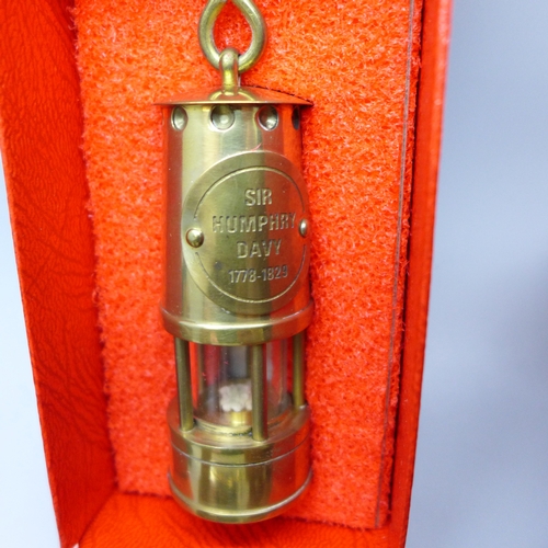 2036 - A small miners lamp marked ‘Sir Humphry Davy 1778-1829’, three carved wooden figures, embroidered ca... 