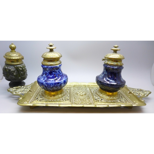 2043 - A brass inkstand with brass mounted ceramic inkwells and one other similar inkwell