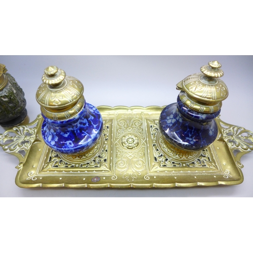 2043 - A brass inkstand with brass mounted ceramic inkwells and one other similar inkwell