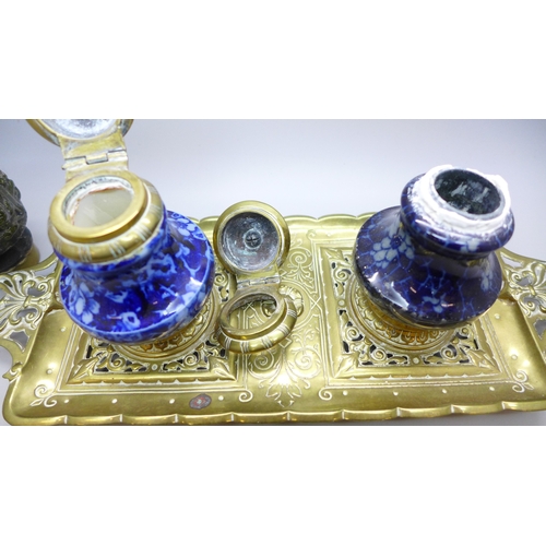 2043 - A brass inkstand with brass mounted ceramic inkwells and one other similar inkwell