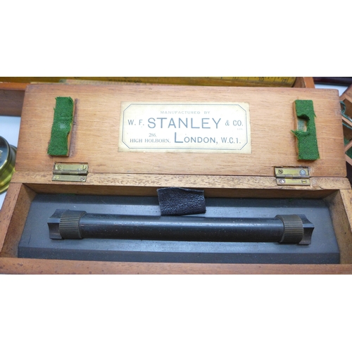 2044 - A Stanley rolling rule, boxed, two other boxes with wooden rulers, a cased set of balance scales wit... 