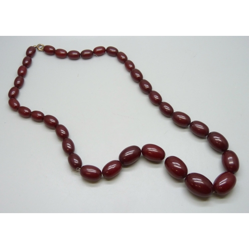 7228 - A string of cherry amber coloured Bakelite beads, 100g, largest bead 2.8cm