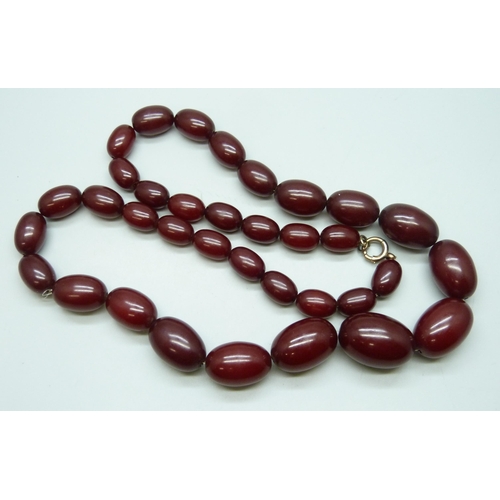 7228 - A string of cherry amber coloured Bakelite beads, 100g, largest bead 2.8cm