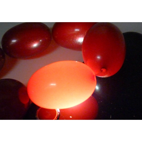 7228 - A string of cherry amber coloured Bakelite beads, 100g, largest bead 2.8cm