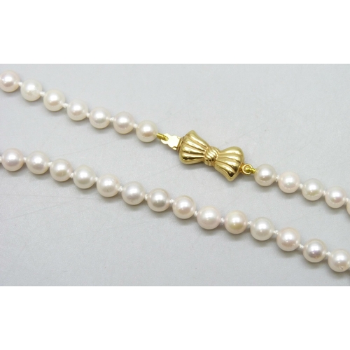7229 - A pearl necklace with a 9ct gold bow clasp, 15.7g, 46.5cm