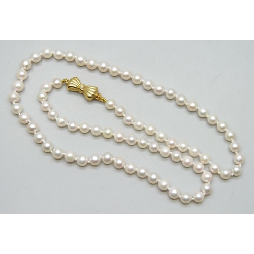 7229 - A pearl necklace with a 9ct gold bow clasp, 15.7g, 46.5cm