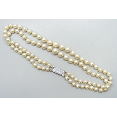 7230 - A double string of cultured pearls with a .800 silver clasp, 40g, 35cm