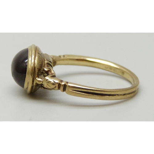 7014 - A 9ct gold ring set with a cabochon garnet, 3.4g, M