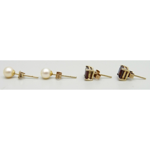 7044 - A pair of yellow metal pearl stud earrings and a pair of 9ct gold and garnet earrings, 1.7g total we... 