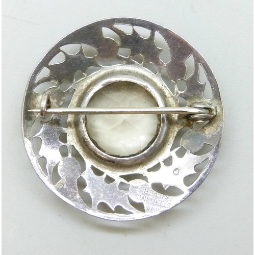 7045 - A Scottish silver brooch with fretwork thistle design and set with a spinel gemstone, 3.3cm
