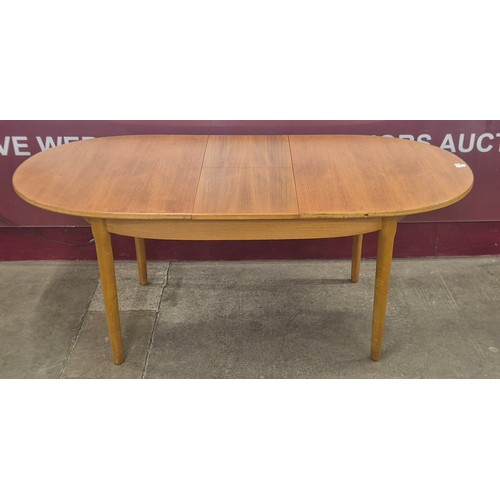 22 - A teak oval extending dining table