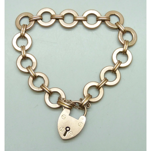7257 - A 9ct gold circle link bracelet with a 9ct gold padlock clasp, 18.9g, 1.3cm wide links