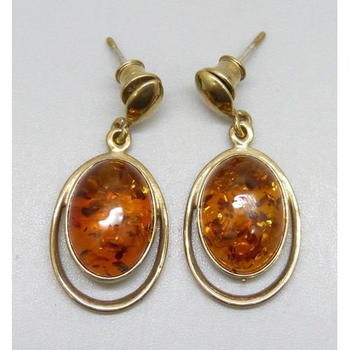7300 - A pair of silver gilt cabochon Baltic amber earrings, plated backings, 3.3cm