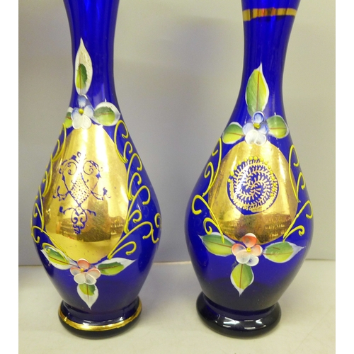 2054 - A collection of cobalt blue glass with raised enamel, four pieces include a burner, jug and two vase... 