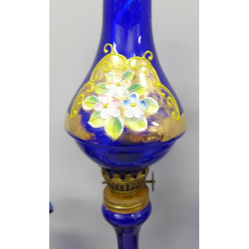 2054 - A collection of cobalt blue glass with raised enamel, four pieces include a burner, jug and two vase... 