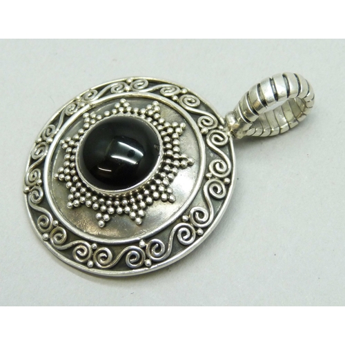 7040 - A large Suarti silver pendant set with a cabochon onyx stone, hallmarked, 22g, 5.5cm including bail