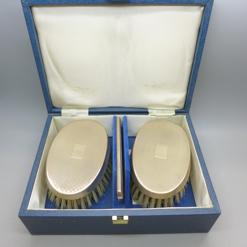7337 - A silver mounted three piece brush/comb set, boxed