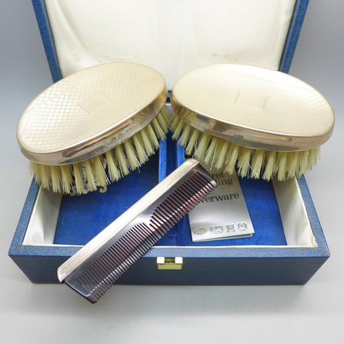 7337 - A silver mounted three piece brush/comb set, boxed