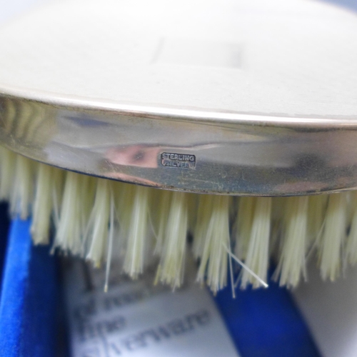 7337 - A silver mounted three piece brush/comb set, boxed
