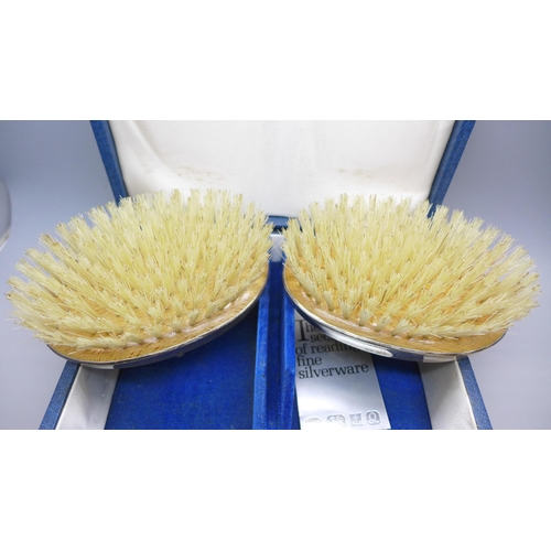 7337 - A silver mounted three piece brush/comb set, boxed
