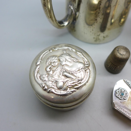 7343 - Nine pieces of silver including a Victorian jug, a pot with embossed figures to lid, an egg cup, a s... 