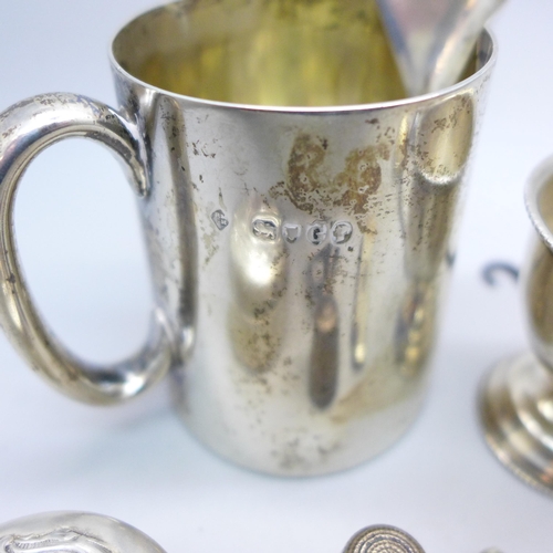 7343 - Nine pieces of silver including a Victorian jug, a pot with embossed figures to lid, an egg cup, a s... 