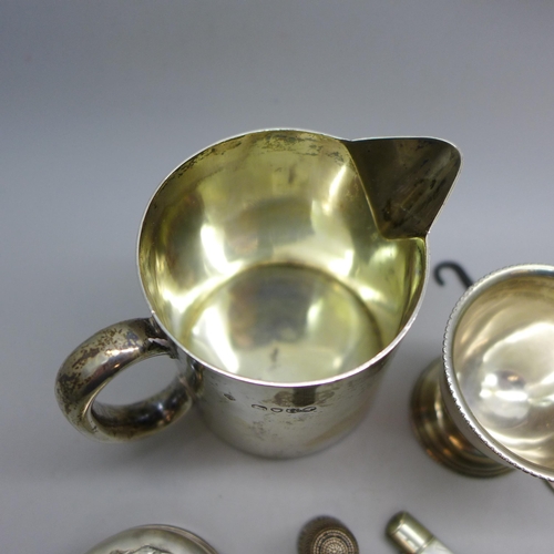 7343 - Nine pieces of silver including a Victorian jug, a pot with embossed figures to lid, an egg cup, a s... 