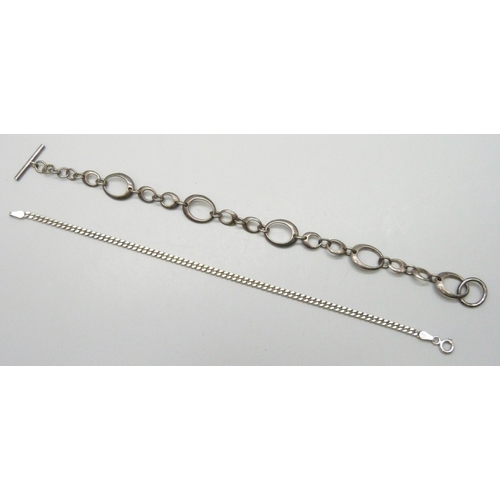 7134 - A silver curb chain bracelet, 17.5cm, and a white metal Modernist design bracelet with T bar fastene... 