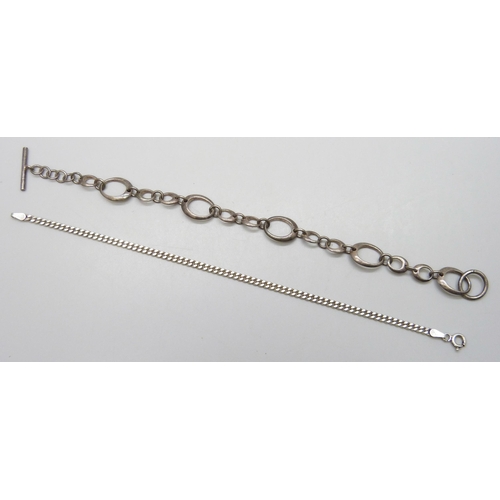 7134 - A silver curb chain bracelet, 17.5cm, and a white metal Modernist design bracelet with T bar fastene... 