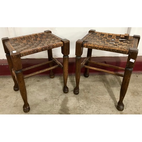 105 - A pair of Arts and Crafts oak and leather topped stools