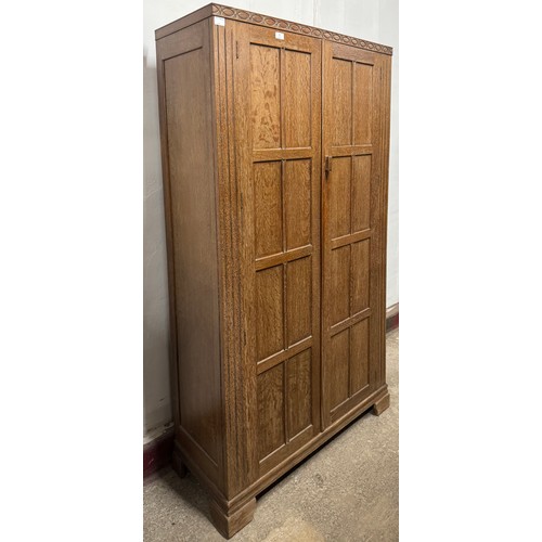 70 - An Art Deco Heals style carved oak two door wardrobe