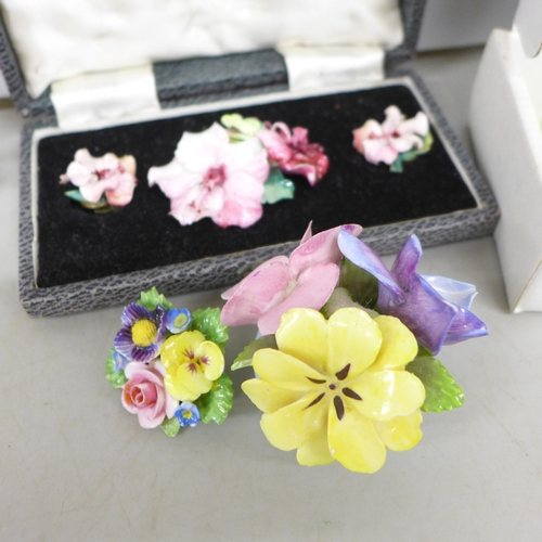 2143 - Two china brooches with a matching pair of earrings, two shoe pin cushions, a china posy, four large... 